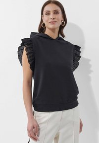 Schwarzes ärmelloses Hoodie mit Rüschendetails an den Schultern, aus weichem Stoff, mit geradem Saum und Kängurutasche.