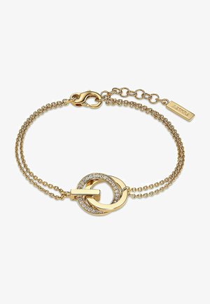 Gul kædearmbånd med to sammenkoblede cirkler. Den ene cirkel har en klar stenaccent. Armbåndet har en krokodillelås og en forlængerkæde.