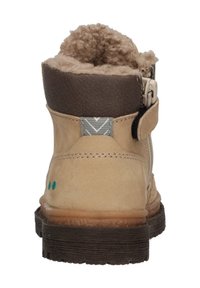 Botas de tobillo de ante marrón claro con un cuello de cuero marrón, forro interior suave, cremallera lateral y una suela de goma marrón texturizada. Puntos de acento verdes.