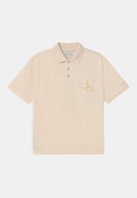 Beżowa koszulka polo z bawełny, z trzema guzikami oraz haftowanym logo "CK" na lewej piersi. Miękka faktura.