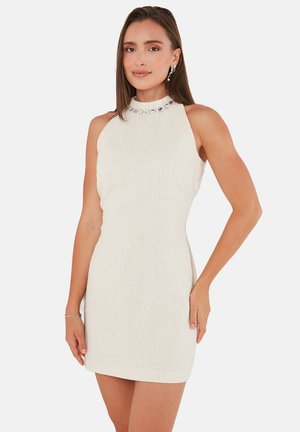 White sleeveless dress made of textured fabric, featuring a high neckline adorned with decorative jewels and a fitted silhouette.