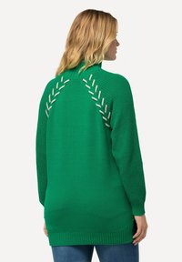 Maglione verde in maglia con vestibilità ampia e orlo a coste, caratterizzato da un motivo decorativo sulla schiena con accenti di cucitura a contrasto.