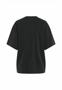 Camiseta negra de gran tamaño con mangas cortas y anchas, cuello redondo y un sutil detalle del logo cerca del escote. Material de algodón suave.