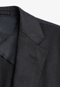 Blazer gris oscuro con una tela texturizada. Las características notables incluyen solapa de pico, un bolsillo y un forro interior suave.