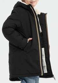 Manteau rembourré noir avec capuche, doté d'une fermeture éclair à l'avant, de poches latérales et d'accents orange sur la fermeture éclair et la doublure intérieure.