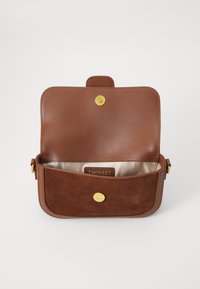 Borsa in pelle marrone e suede con chiusura a scatto dorata, un unico scomparto e un interno con rivestimento in tessuto e etichetta del marchio.
