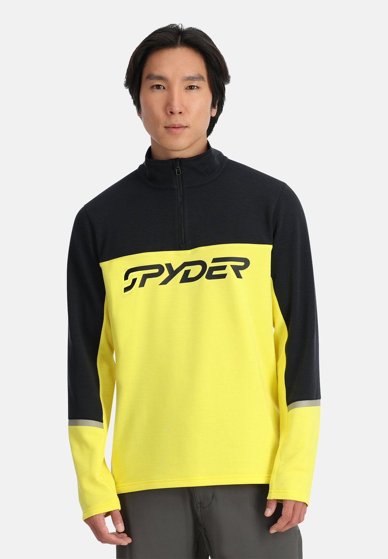 Pullover in pile giallo e nero con colletto a metà zip, caratterizzato da un grande logo "SPYDER" in nero e dettagli grigi sulle maniche.
