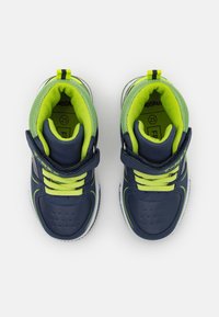 Adidași bleumarin cu accente verde lime, design perforat pe vârf, talpă flexibilă, vârf rotund și curea cu arici pentru o fixare sigură.