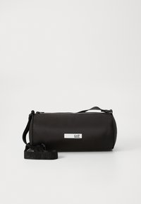 Borsa cilindrica nera in tessuto liscio, con zip superiore e tracolla regolabile con un tocco di branding. Design compatto.