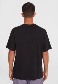 Black cotton t-shirt with a crew neck and short sleeves. Simple design with a straight cut, no patterns or accents. Tag visible at hem.
