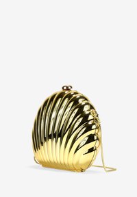 Clutch dorado en forma de concha con textura acanalada, acabado metálico y una correa de cadena desmontable. Presenta un pequeño cierre en la parte superior.