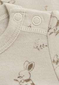 Krämfärgad bomullsonezie med bruna tryckta kaninmönster, tryckknappar vid axeln och en mjuk textur med ribbad halsringning.