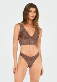 Braun Spitzen-Bralette mit tiefem V-Ausschnitt und gewelltem Saum, kombiniert mit passendem Spitzen-Höschen. Glatte Textur, zartes Blumenmuster.