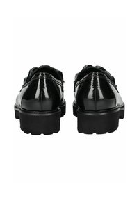 Zapatos de charol negro con punta redonda, suelas gruesas negras y un ligero tacón, que presentan costuras cosidas y un acabado pulido.