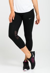 Czarne legginsy capri z siateczkowymi wstawkami. Wykonane z elastycznego materiału, charakteryzujące się gładką teksturą i małym srebrnym logo po boku.