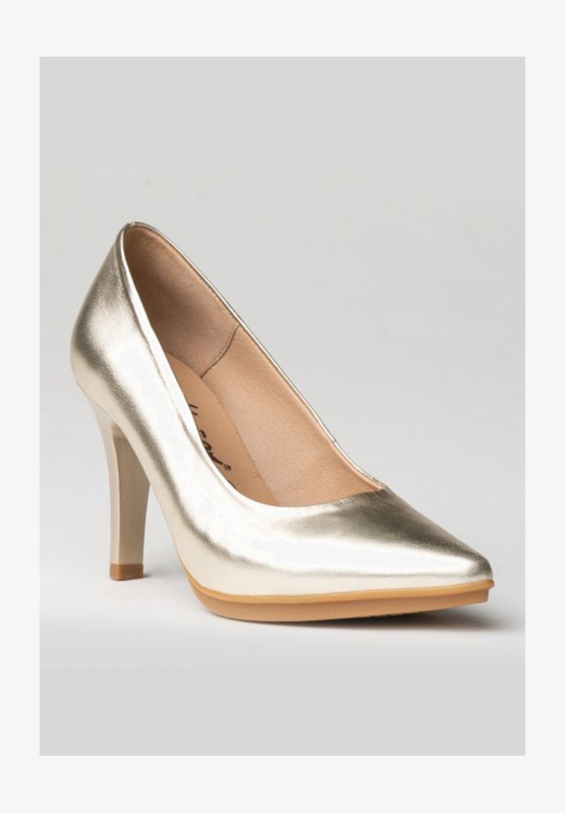 Zapato de tacón alto metálico dorado con punta afilada, superficie suave y un tacón fino tipo estilete. El interior presenta un forro beige.