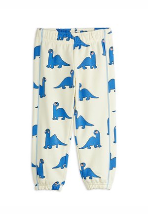 Pantalon crème pour enfants avec taille élastique et chevilles élastiques, décoré d'un motif répétitif de dinosaures bleus en cartoon.