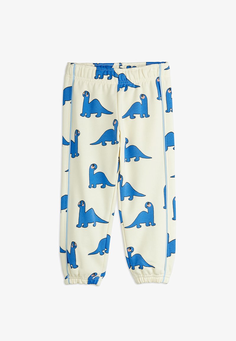 Detské krémové nohavice s elastickým pásom a členkami, zdobené opakujúcim sa modrým vzorom s rozprávkovými dinosaurami.