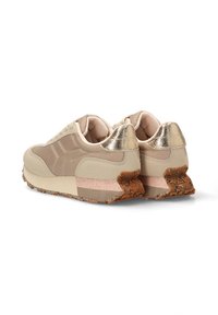 Zapatillas beige con un upper de tela texturizada, acentos dorados en el talón y una suela de goma marrón con motas. Diseño deportivo clásico.