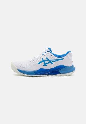 Weißer Sportschuh mit blauen Akzenten, ausgestattet mit einem strukturierten Obermaterial, Schnürverschluss und einer robusten Gummisohle, die für Leistung ausgelegt ist.