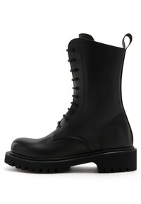 Stivale in pelle nera con lacci, punta tondeggiante, caviglia alta e suola in gomma spessa con motivo antiscivolo. Presenta una linguetta sul retro.