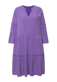 V-muotoinen, kolmannes hihoilla ja kerroksellinen violetti mekko. Valmistettu sileästä kankaasta, jossa on rypytettyjä yksityiskohtia kerroksissa.