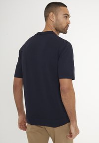 Námořnický svetr s krátkým rukávem s žebrovaným límcem a lemem. Vyroben z měkkého materiálu, s volným střihem a hladkou texturou.