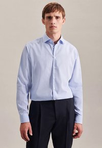 Camicia azzurro chiaro con un piccolo motivo a quadri, vestibilità sagomata, maniche lunghe e colletto standard, abbinata a pantaloni neri.