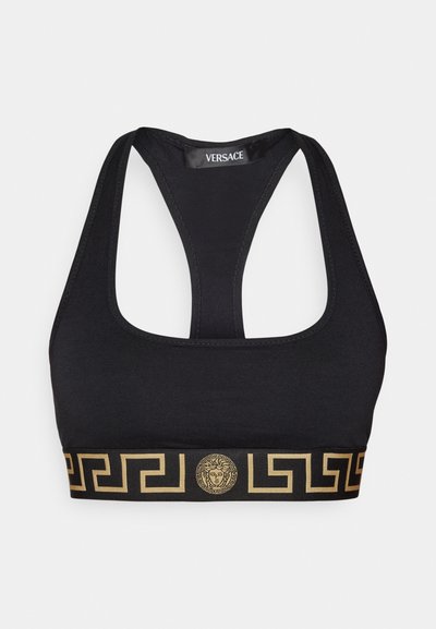 Schwarzer Sport-BH mit Racerback-Design, featuring einem goldenen geometrischen Muster und dem Medusa-Emblem an dem Band. Hergestellt aus einem glatten Stoff.