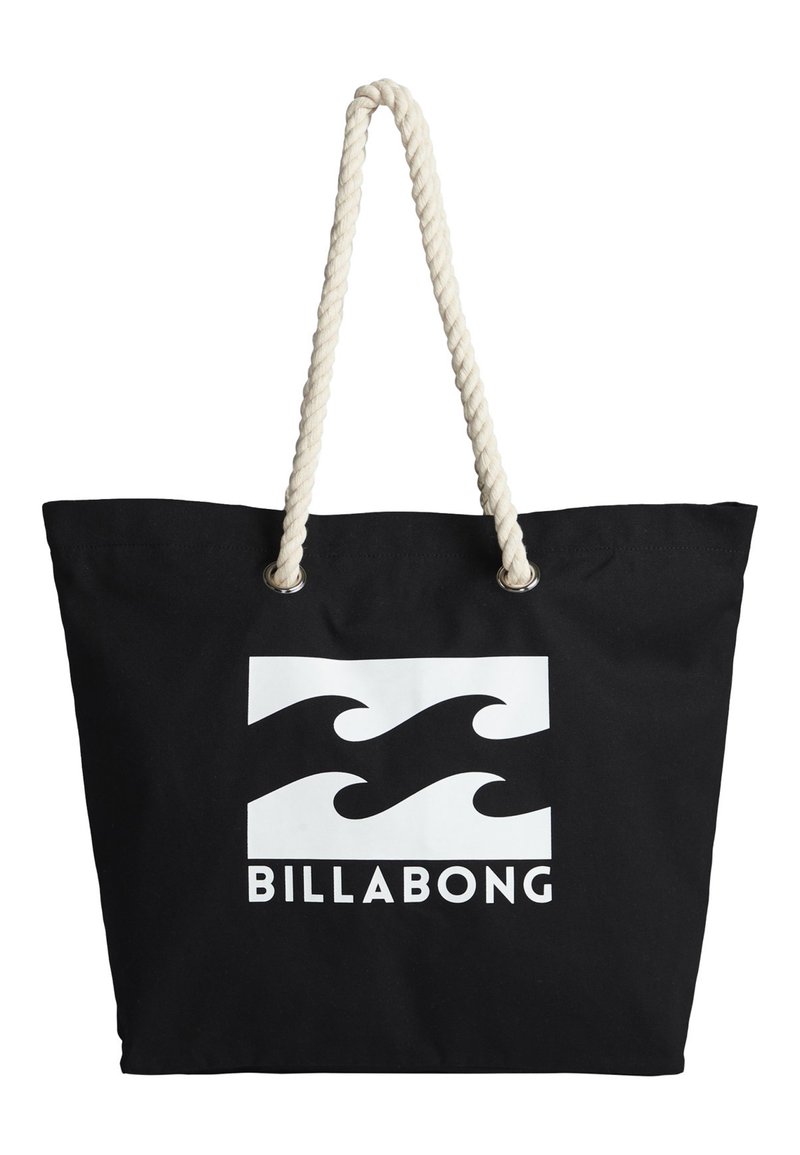 Black canvas tote bag with white wave logo and "BILLABONG" text. Features thick, twisted cream-colored rope handles and metallic eyelets.