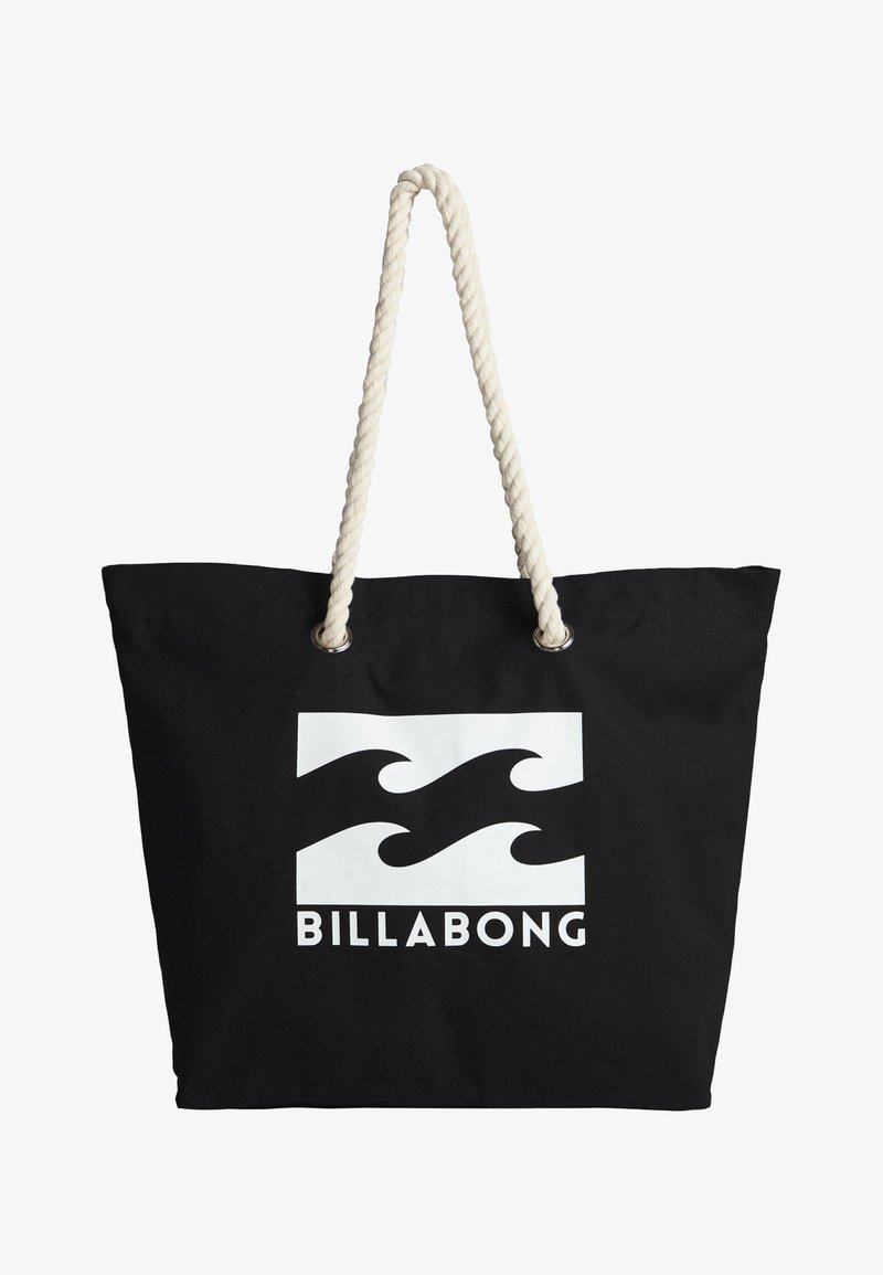 Black canvas tote bag with white wave logo and "BILLABONG" text. Features thick, twisted cream-colored rope handles and metallic eyelets.