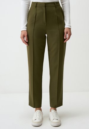 Pantaloni su misura color verde oliva con vita alta, caratterizzati da pieghe frontali, gambe affusolate e abbinati a scarpe da ginnastica bianche. Tessuto dal tocco morbido.