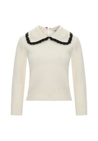 Pull crème avec un large col noir en dentelle, des manches longues et des poignets côtelés. Le dos présente une petite ouverture en forme de clé.