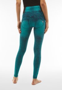 Leggings turchesi a vita alta con finitura testurizzata, finte tasche frontali e tasche posteriori curvate, caratterizzati da un tessuto morbido per il massimo comfort.