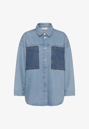 Hele sinine teksajope tumedate siniste rinnataskute, hõbedaste snap-nööpide ja terava kraega, valgel taustal.