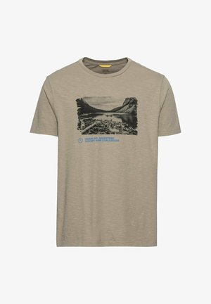 Camiseta marrón claro con estampado en blanco y negro de lago y montaña, dos personas en canoa y texto azul "Comparte una aventura, acepta nuevos desafíos."