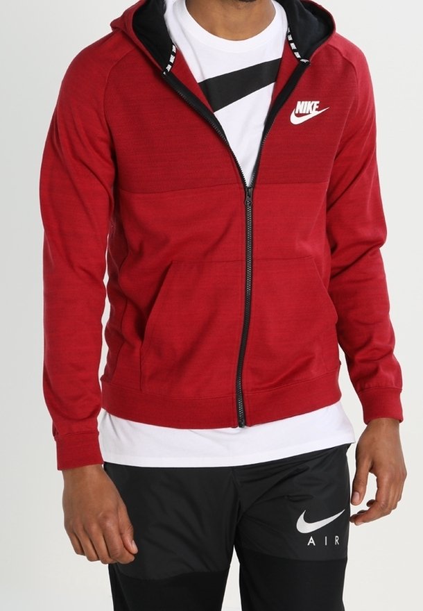 Červená mikina s kapucí na zip, s černým vnitřním materiálem kapuce, s bílým logem Nike na hrudi a texturovanou tkaninou s přiléhavým střihem.