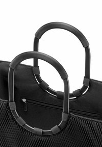 Schwarze Stofftasche mit zwei ovalen, gerippten Griffen, einer Reißverschlusstasche und einer Netzseitentasche.