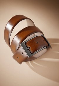 Cintura in pelle marrone con finitura strutturata, dotata di fibbia metallica rettangolare. Il design include più fori per la regolazione e bordi lisci.