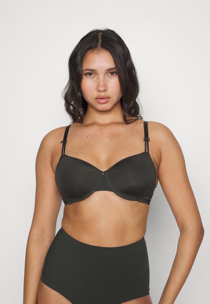 Black semi-padded bra with adjustable straps, smooth texture, and a clasp closure. Paired with high-waisted black underwear.