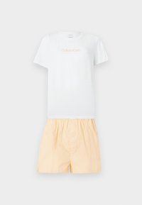 Λευκό κοντομάνικο t-shirt Calvin Klein με λογότυπο σε ανοιχτό πορτοκαλί, συνδυασμένο με άνετο σορτς σε ανοιχτό ροδακινί χρώμα με ελαστική μέση.