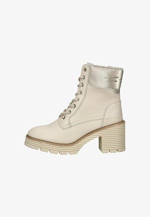 Botte de cheville blanche à lacets avec un dessus en cuir lisse, accent métallique, talon épais strié et semelle texturée pour une meilleure traction.