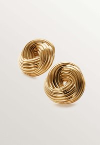 Pendientes de metal en tono dorado con un diseño de espiral retorcida, que presentan formas redondeadas y una superficie texturizada, reflejando la luz.