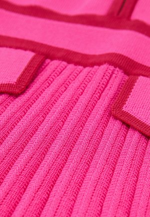 Neulottu vaatekappale kirkkaan pinkkinä, jossa on teksturoitu resori ja kontrastiväriset punaiset yksityiskohdat. Siinä on leveät, vaakasuorat raidat ja pehmeä viimeistely.