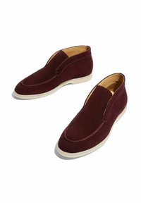 Bottines en daim bourgogne à enfiler avec des semelles en caoutchouc blanches. Présentent un orteil cousu et une doublure intérieure lisse. Texture douce et silhouette épurée.