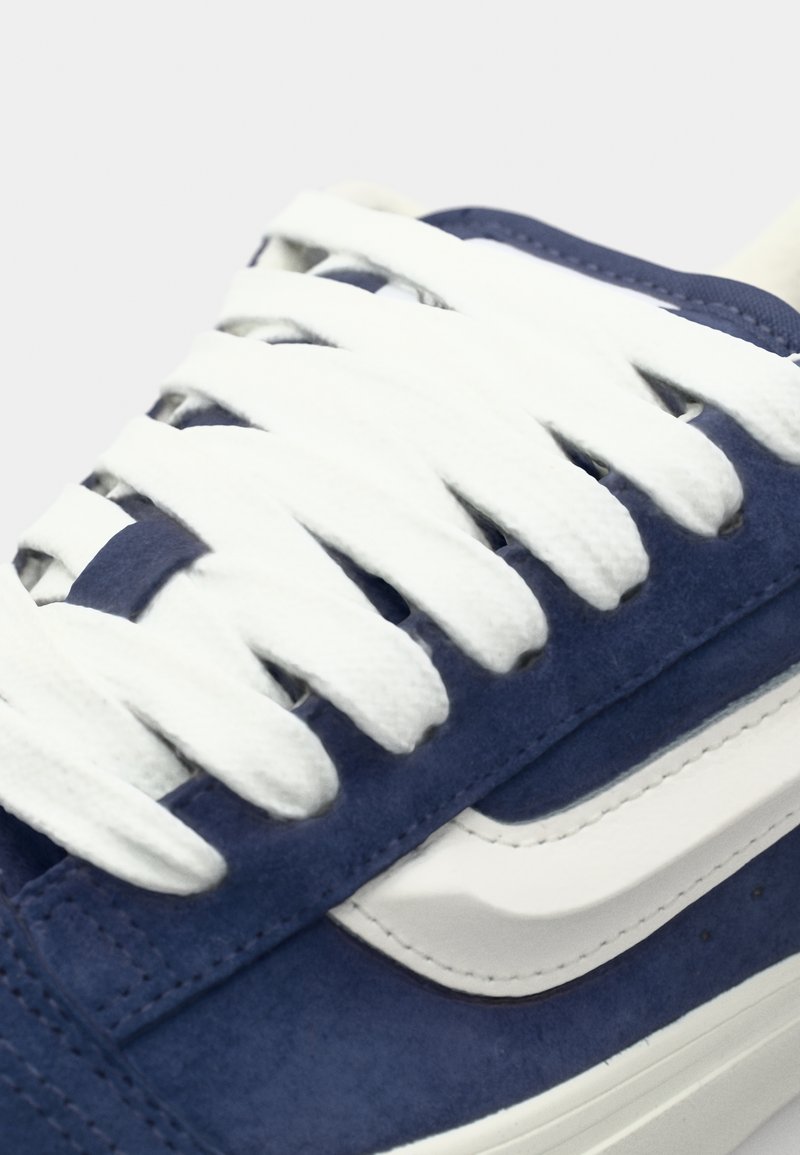 Blaue Wildledersneaker mit weißen Schnürsenkeln, ausgestattet mit einer strukturierten Oberseite und seitlichen Streifen. Sauberes Design mit abgerundeter Zehenpartie und kontrastierender Sohle.