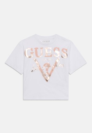 Hvid T-shirt med korte ærmer og rosaguld metalisk tekst "GUESS EST. 1981 Los Angeles" samt trekantet logo på forsiden.