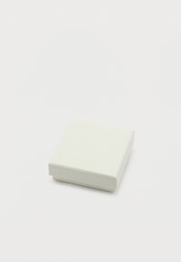 Μικρό κλειστό λευκό τετράγωνο κουτί κοσμημάτων σε απλό λευκό φόντο, με θέα ελαφρώς από πάνω και από το πλάι.