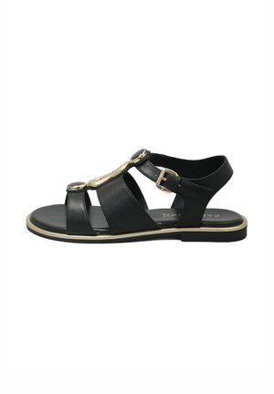Sandalo in pelle nera con tre cinturini frontali, accessori in metallo dorato e fibbia regolabile. Suola piatta con un dettaglio in oro.