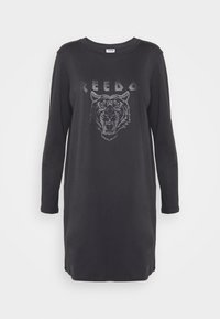Vestido de algodão preto de mangas compridas, com um gráfico de tigre e a palavra "REBEL" em acabamentos brilhantes ao longo do peito. Design simples com gola arredondada.